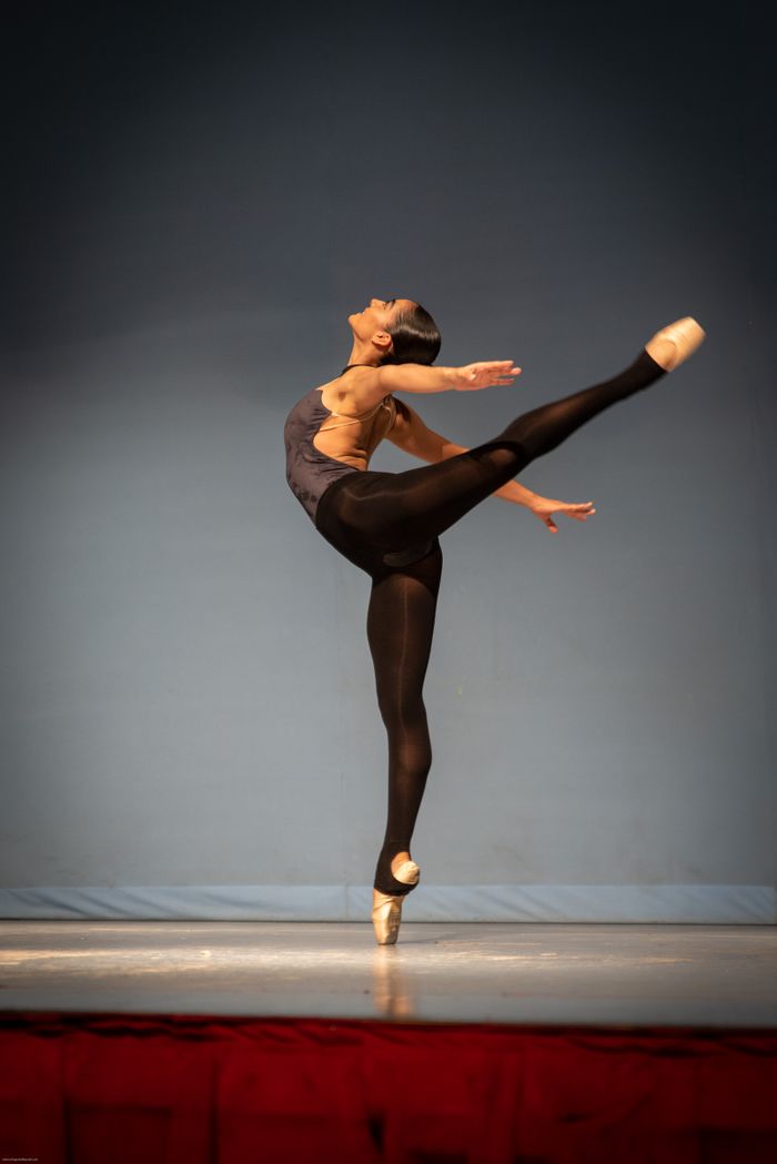 Graceful ballerina in mid-pose showcasing classical ballet on stage.