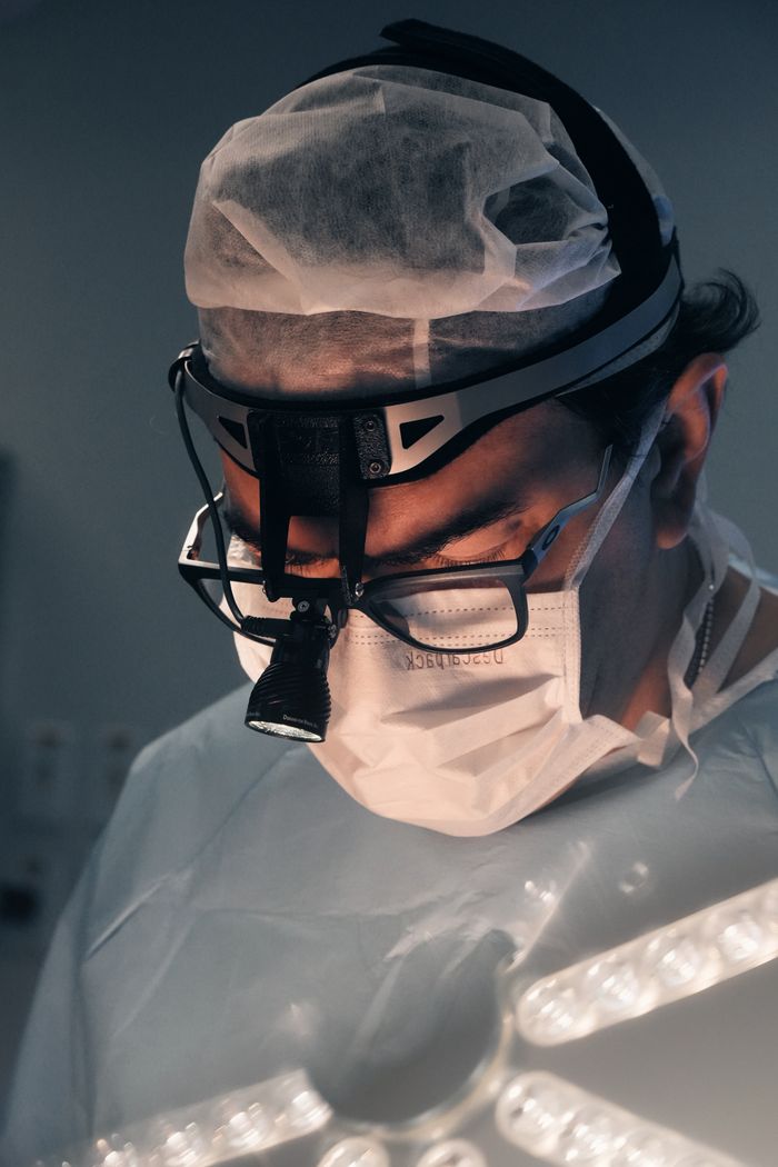 A skilled surgeon focused during an operation in a sterile operating room.